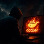 Людина у капюшоні працює за ноутбуком з логотипом Docker на екрані.
