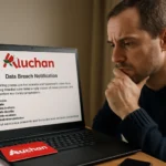 Man looks concerned while reading a data breach notification on a laptop.