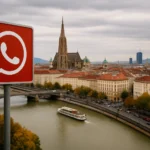Rotes WhatsApp-Symbol vor einer Stadtansicht mit Fluss und Kirche.