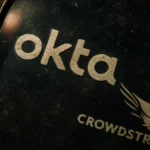 Логотипы компаний Okta и CrowdStrike на темном фоне с бликами света.