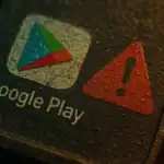 Google Play logo next to a red warning triangle on a textured surface.