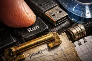 Пальцы нажимают на клавишу "Run" с рядом кабелей и бумаги.