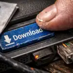 Finger drückt auf einen blauen "Download"-Button neben Kabelanschlüssen.