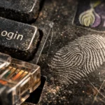 Fingerprint imprinted on a dusty keyboard beside a "Login" key.