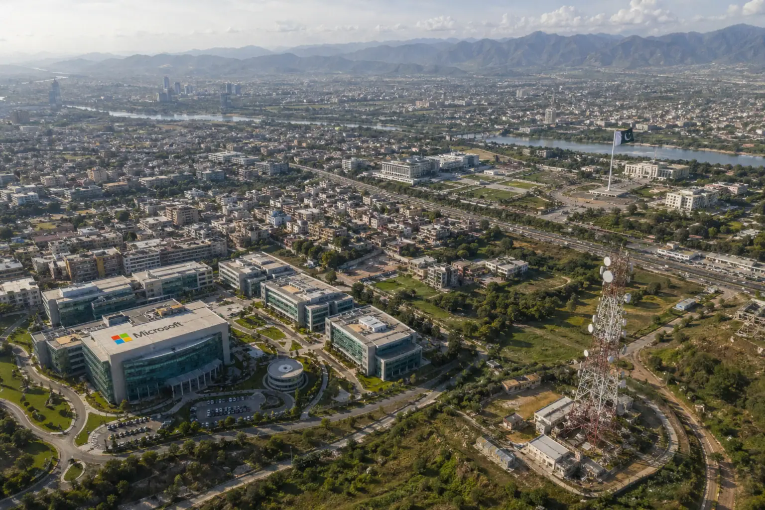 Vista panorámica de una ciudad moderna con edificios y montañas de fondo.