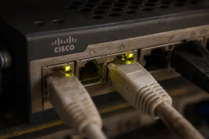 Cisco router showing connected Ethernet cables with glowing indicators.
